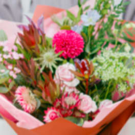 Mixed bouquet with pink and green flowers wrapped in pink paper