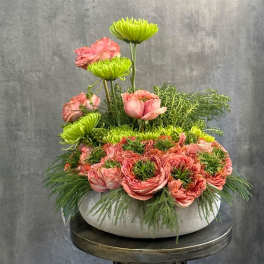 Pink roses and green chrysanthemums in a low white bowl