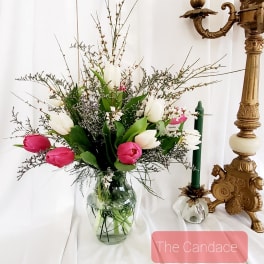 Pink and white tulips in a glass vase with airy filler