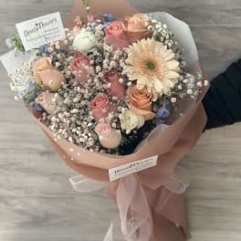 Bouquet of pink and peach roses with a pale gerbera daisy