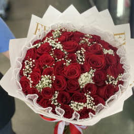 Bouquet of red roses with white baby's breath in white wrapping