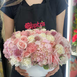 Pink and white rose arrangement in a white hat box with ribbon