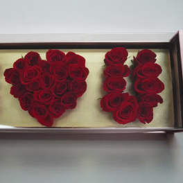 Red roses arranged in a rectangular display box spelling "I ♥ U"