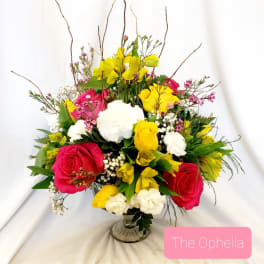 Bright mixed bouquet of pink, yellow, and white flowers in a glass vase