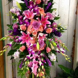 Tall floral spray with pink lilies, roses, and purple orchids