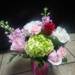 Pink and white mixed flower arrangement in a pink vase
