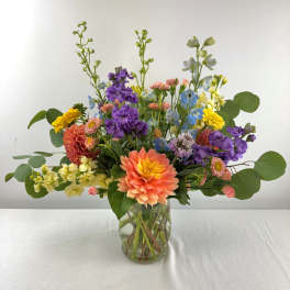 Mixed bouquet of colorful flowers in a clear glass vase