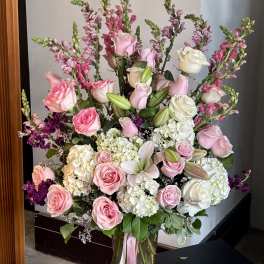 Large pink and white flower arrangement in a glass vase