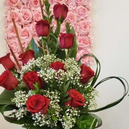 Basket arrangement of red roses with white filler flowers