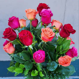 Bouquet of red, pink, and peach roses in a glass vase