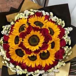 Bouquet of sunflowers and red roses wrapped in black and gold paper