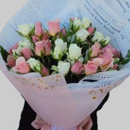 Bouquet of pink and white roses wrapped in pastel paper