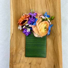 Colorful flower arrangement on a green rectangular base