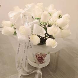 White rose bouquet in a round box with a ribbon