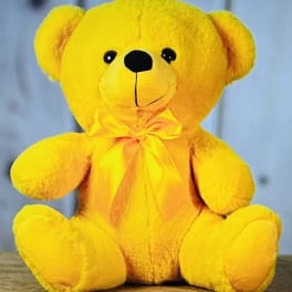 Yellow teddy bear with a satin bow