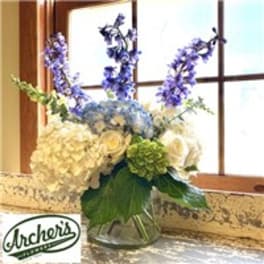 Blue and white floral arrangement in a glass vase