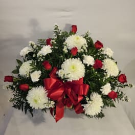 Red roses and white chrysanthemums arranged with a red ribbon