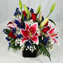 Bouquet of red roses and pink lilies in a black vase
