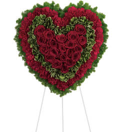 Heart-shaped standing floral tribute with red roses and carnations