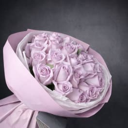 Bouquet of pale lavender roses wrapped in pink paper