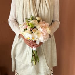 Bride holding a pastel bouquet of white and blush flowers