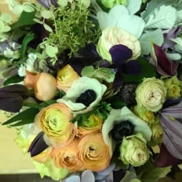 Bouquet of pale peach, white, and dark purple flowers
