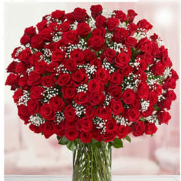 Large bouquet of red roses with baby's breath in a clear glass vase