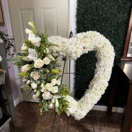 White floral heart-shaped standing spray on an easel