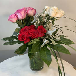 Bouquet of pink, red, and white roses in a glass vase