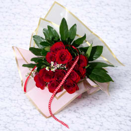 Bouquet of red roses with pink wrapping and a red ribbon