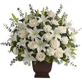 White lilies and cream roses arranged in a brown urn vase