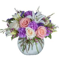 Bouquet of pink and white roses with purple flowers in a glass vase