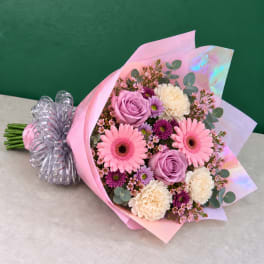 Pink and lavender bouquet with gerbera daisies, roses, and carnations wrapped in pink paper