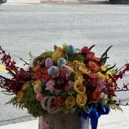 Colorful bouquet of roses with pastel Easter eggs in a box