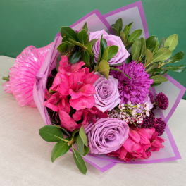 Bouquet of pink and lavender flowers wrapped in purple paper