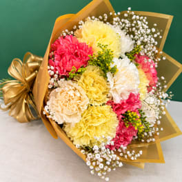 Bouquet of colorful carnations wrapped in gold paper with a ribbon