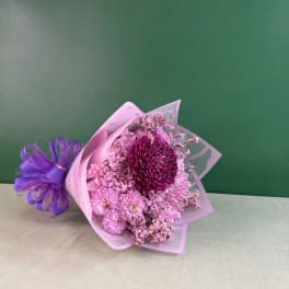 Pink and purple chrysanthemum bouquet wrapped in translucent paper