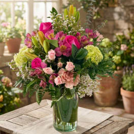 Mixed pink and green flower arrangement in a glass vase