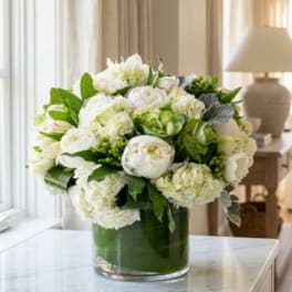 White floral arrangement in a clear glass vase on a table