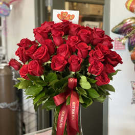 Bouquet of red roses in a glass vase with a red ribbon