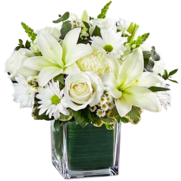 White lilies and daisies arranged in a square glass vase