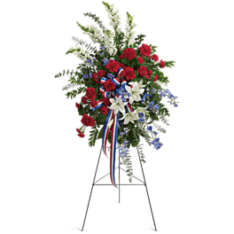 Standing floral spray with red, white, and blue flowers on an easel