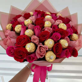 Bouquet of red and pink roses with gold-wrapped chocolates