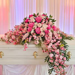 Pink and white floral casket spray with cascading blooms
