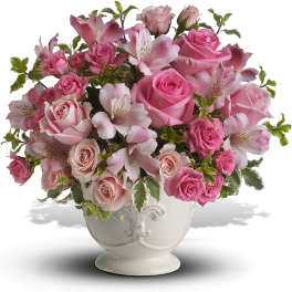 Pink roses and lilies arranged in a white vase