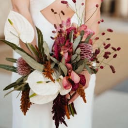 Bride holding a bouquet of white anthuriums and pink orchids
