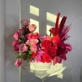Pink and red rose arrangement in a white vase