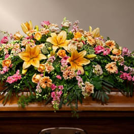 Large casket spray with yellow lilies, roses, and pink flowers