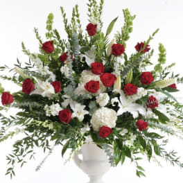 Large red and white floral arrangement in a white vase