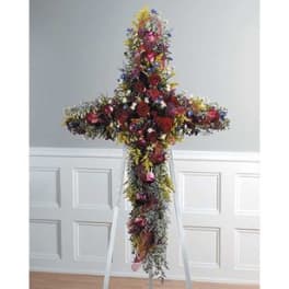 Tall floral cross arrangement on a stand with multicolored flowers
